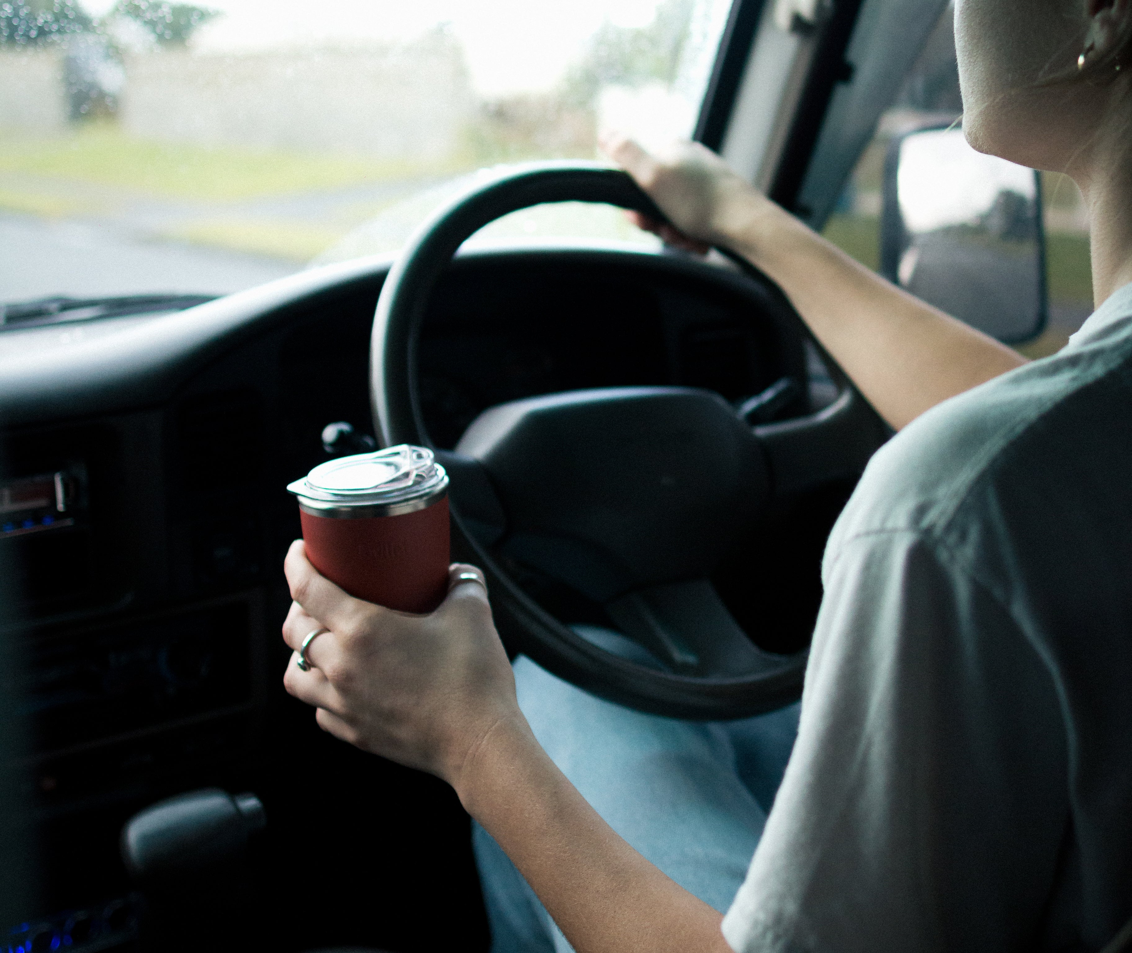reusable coffee cup held while driving