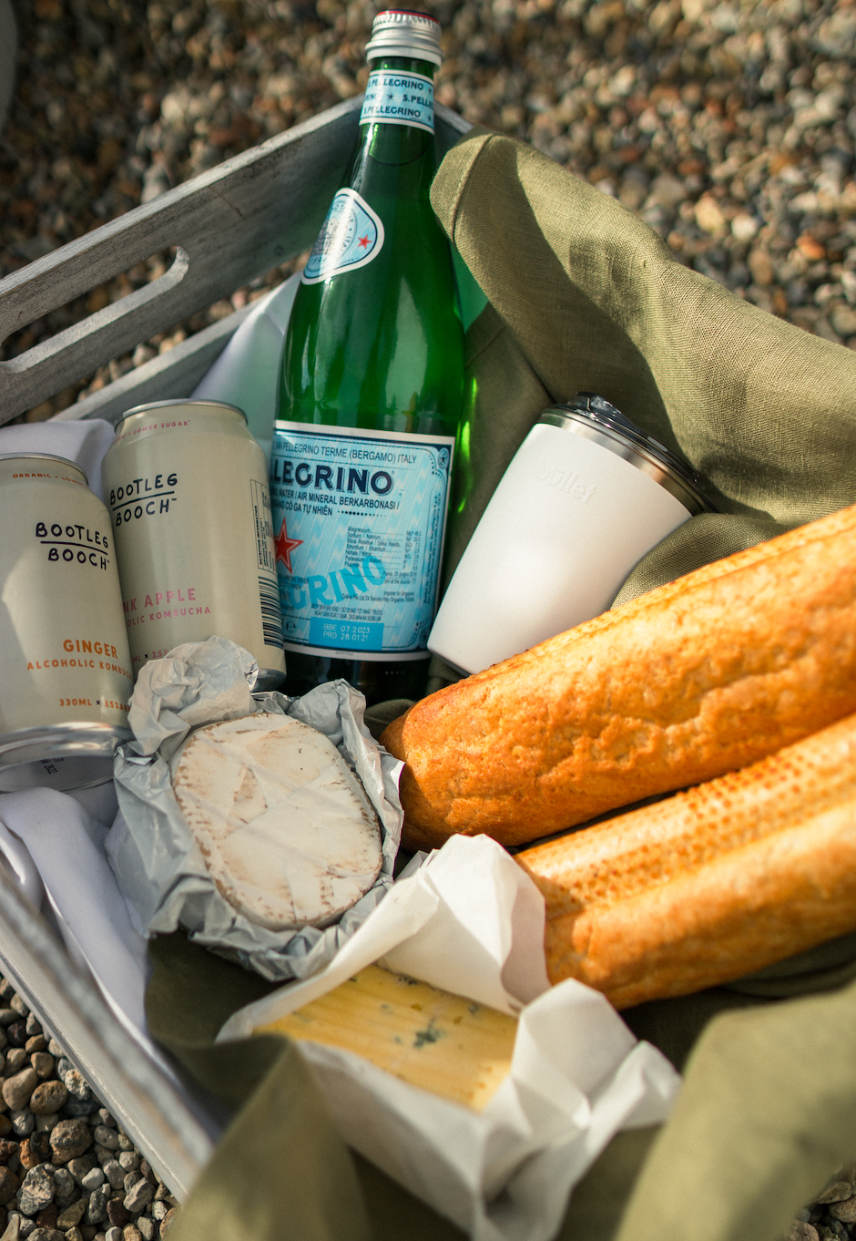 reusable coffee cup amongst picnic food and drink